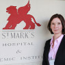 Dr Ailsa Hart standing next to the entrance sign for St Mark's Hospital.